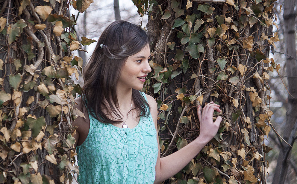 young girl next to tree