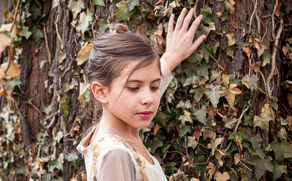 young girl next to tree
